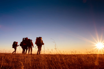 Hikers is walking on plateau in Crimea mountains during sunset