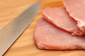 Fresh pork meat and knife on cutting board