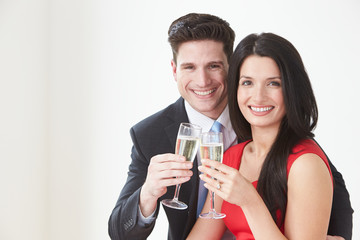 Studio Portrait Of Couple Celebrating With Champagne