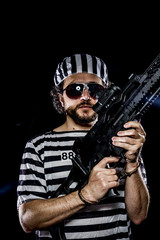 Security.Prison riot concept. Man holding a machine gun, prisone
