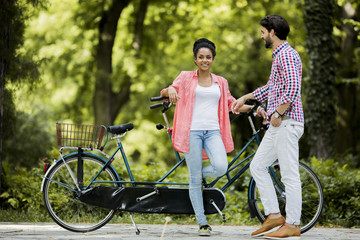 Obraz premium Young couple riding on the tandem bicycle