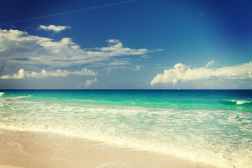 blue sea or ocean, white sand and sky with clouds