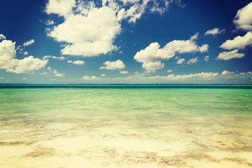blue sea or ocean, white sand and sky with clouds
