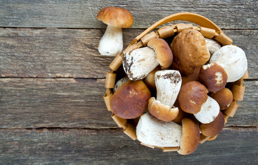 boletus mushrooms in a basket on wooden surface