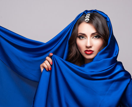 Portrait of a beautiful young woman in blue fabric