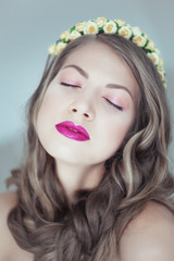 Portrait of beautiful woman with flowers in hair and blue eyes