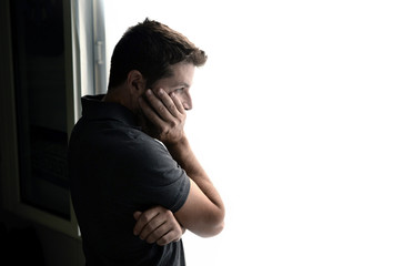 attractive man looking through window suffering depression