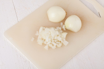Fototapeta na wymiar Whole, peeled and diced brown onion