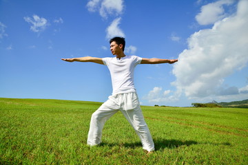 Fototapeta na wymiar portrait of healthy young man doing yoga against sky