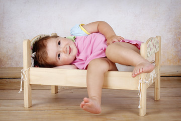 Little baby girl lying in the small bed