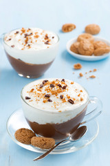 dessert with chocolate, cream and amaretti on blue background