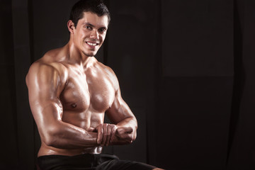 Muscular male bodybuilder, on a dark background.