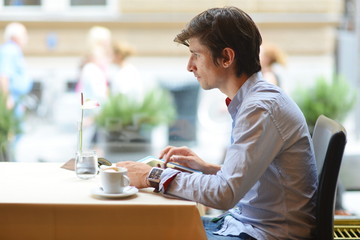 Young fashion man / hipster drinking coffee with tablet computer