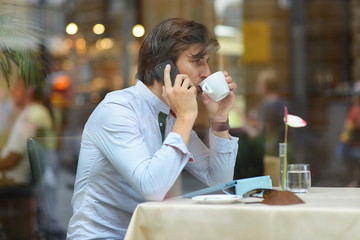 Young fashion man / hipster drinking coffee with tablet computer