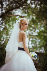 portrait of beautiful young woman in white dress walking in park