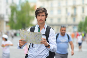 Young tourist watching the map in the city center