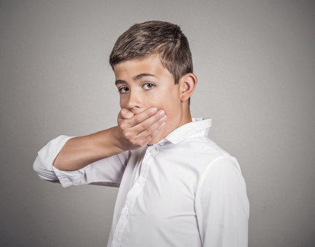 Man looking surprised, hand covering mouth grey background 