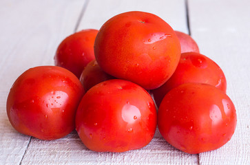 raw red tomatoes on a white wooden board