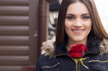 Pretty young brunette woman and red rose.
