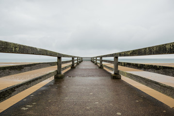 Fototapeta premium Pier in the Omaha beach. Omaha beach is located on the coast of
