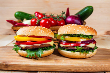 homemade hamburger with fresh vegetables on cutting board