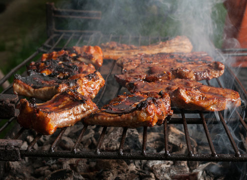 Pork meat and ribs on grill outdoors.