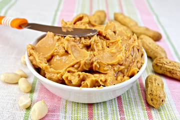 Butter peanut with a knife on tablecloth