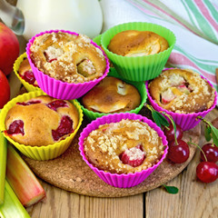 Cupcakes with rhubarb and cherries in tins on board