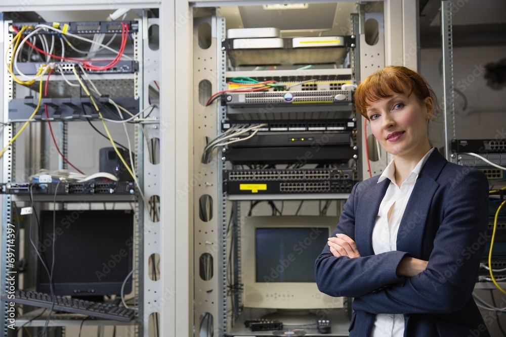 Aufkleber Pretty computer technician smiling at camera beside server