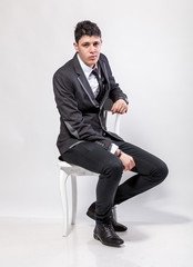stylish businessman sitting on white wooden chair