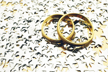 Gold wedding rings with silver stars on gold background