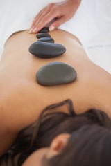 Obraz na płótnie Canvas Beautiful brunette enjoying a hot stone massage