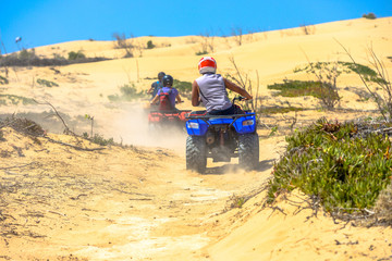 Two quads racing after one another in deserted dusty areas