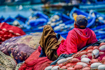 A man sewing fishing nets
