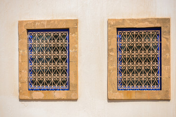 Two identical windows next to one another on a white wall