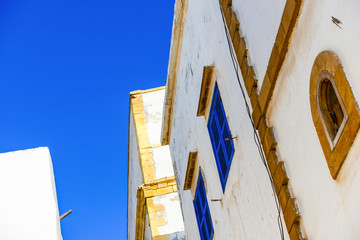 White wall with blue windows and yellow frames