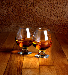 Two goblets of brandy on wooden old counter top