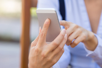 Cropped image woman hands holding, using smartphone