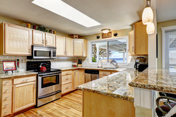 Bright kitchen with granite tops and skylight