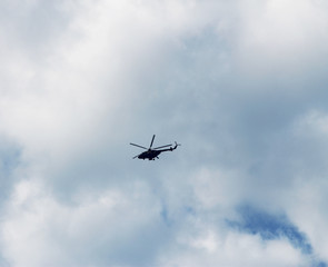 Fototapeta na wymiar Helicopter flightning in blue sky with clouds