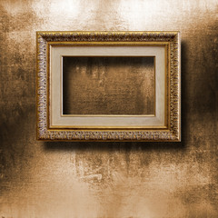 Old gilded picture frame for  portrait on  shabby cement wall