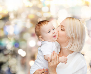 happy mother kissing smiling baby