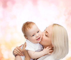 happy mother kissing smiling baby