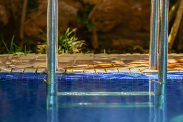 Closeup to blue water and pool metalic railings