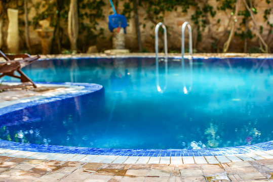 Blue swimming pool situated in the middle of the backyard