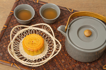 Chinese moon cake with tea ceremony on wooden background