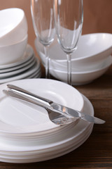 Set of white dishes on table on brown background