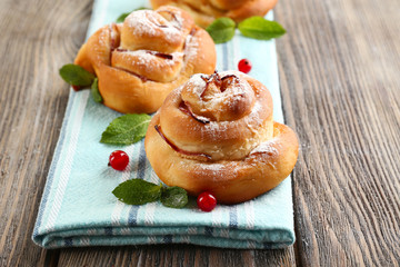 Tasty buns with berries on table close-up