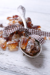 Reed sugar in spoon on wooden background
