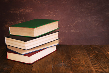 Books on wooden table on dark background
